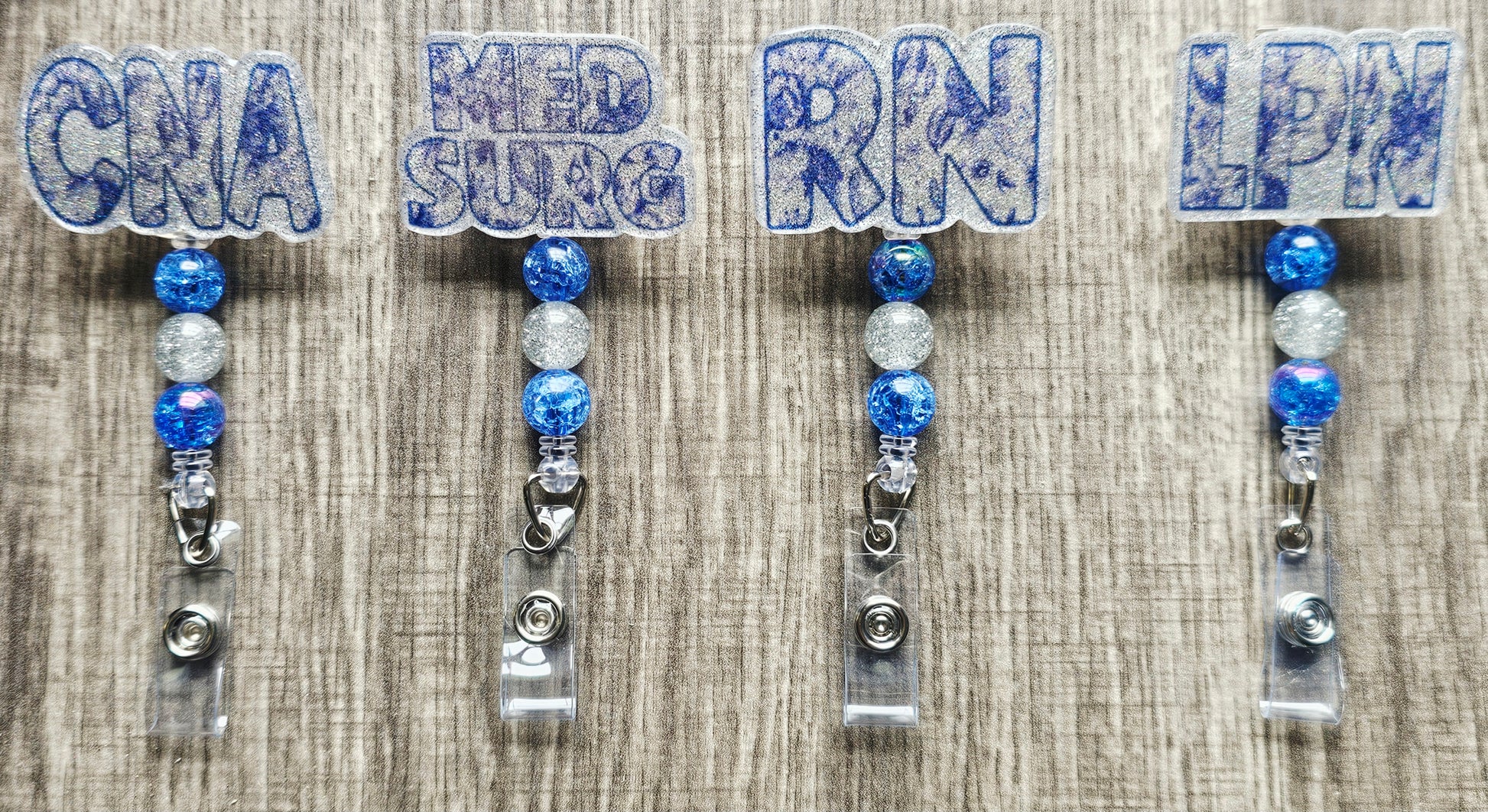 White and blue pattern badge reel with MED SURG text and blue-toned beads.