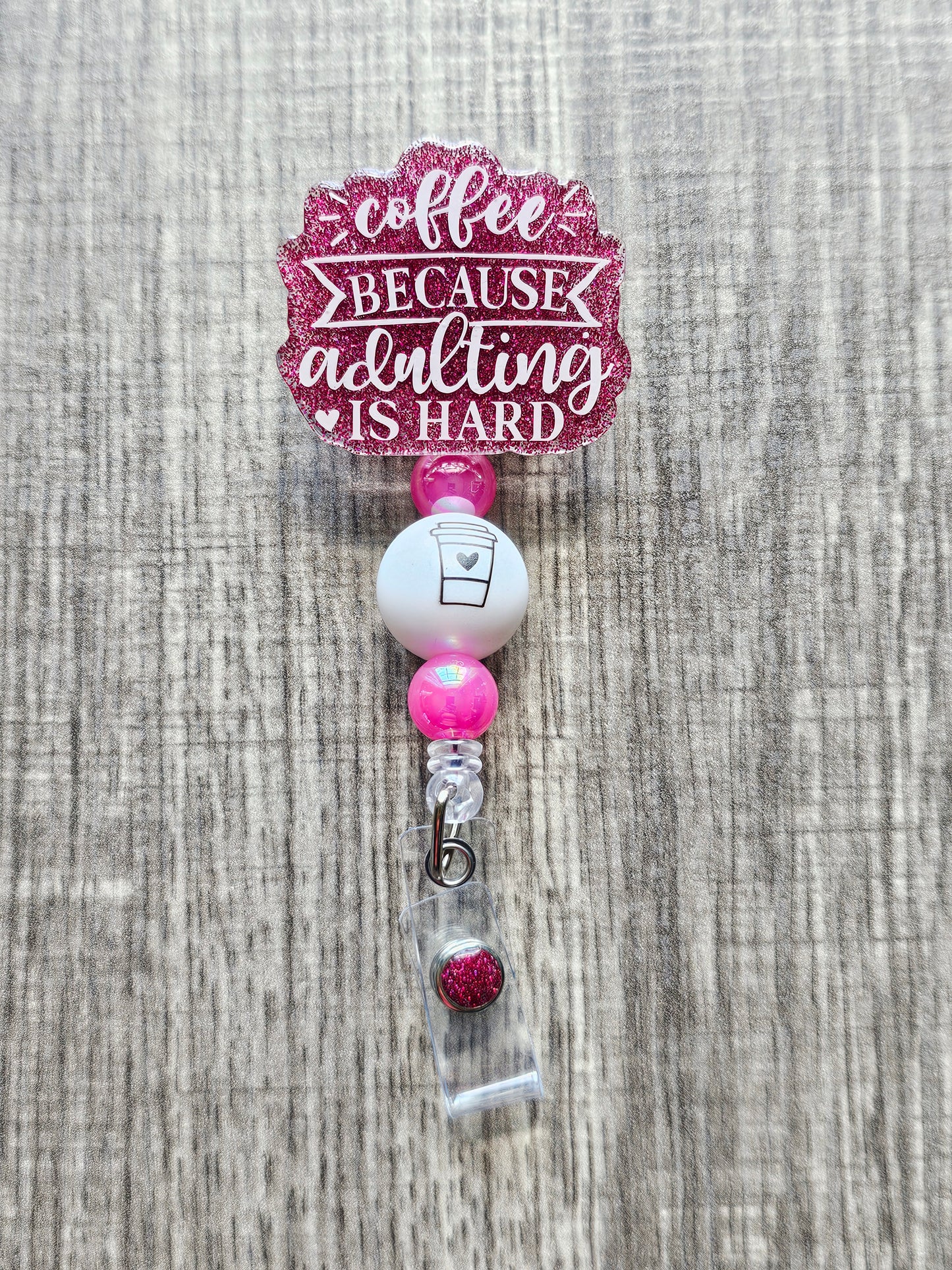 Humorous badge reel that says "Coffee Because Adulting is hard" with a coffee cup embedded on its bead.