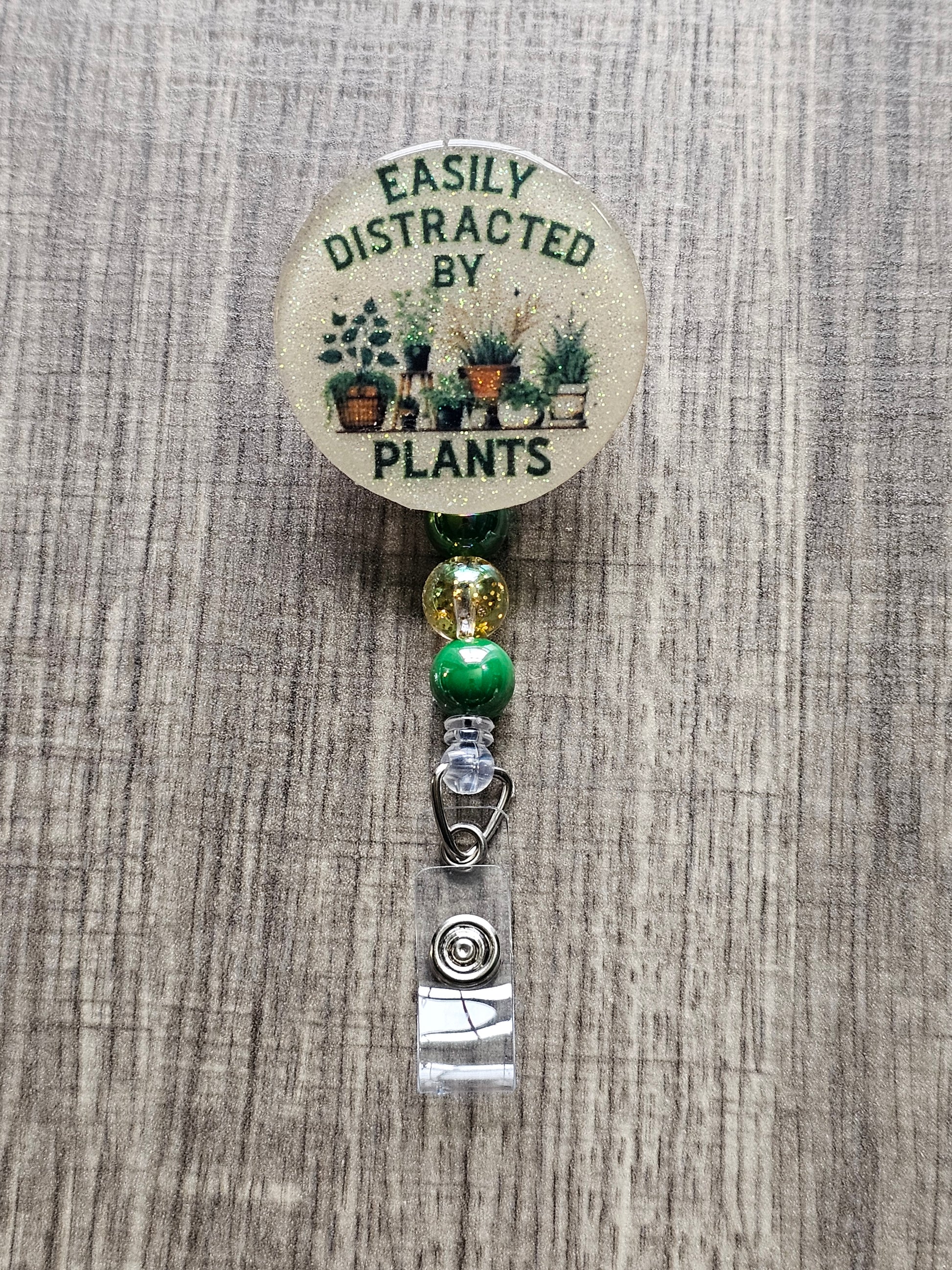 Easily Distracted by Plants badge reel with nature-inspired background