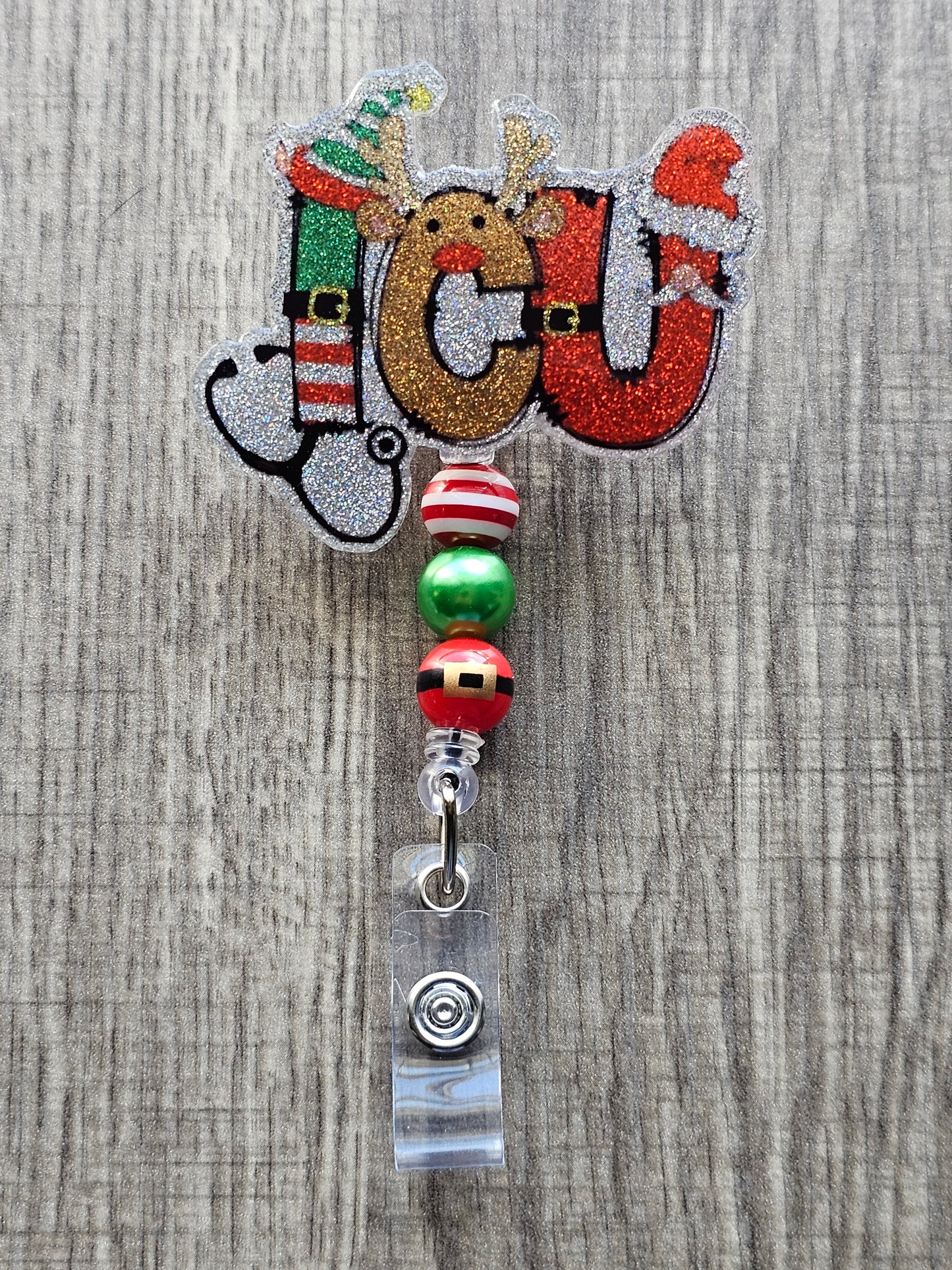 A badge reel stating ICU while the letters are decorated in a festive manner paired with a stethoscope.