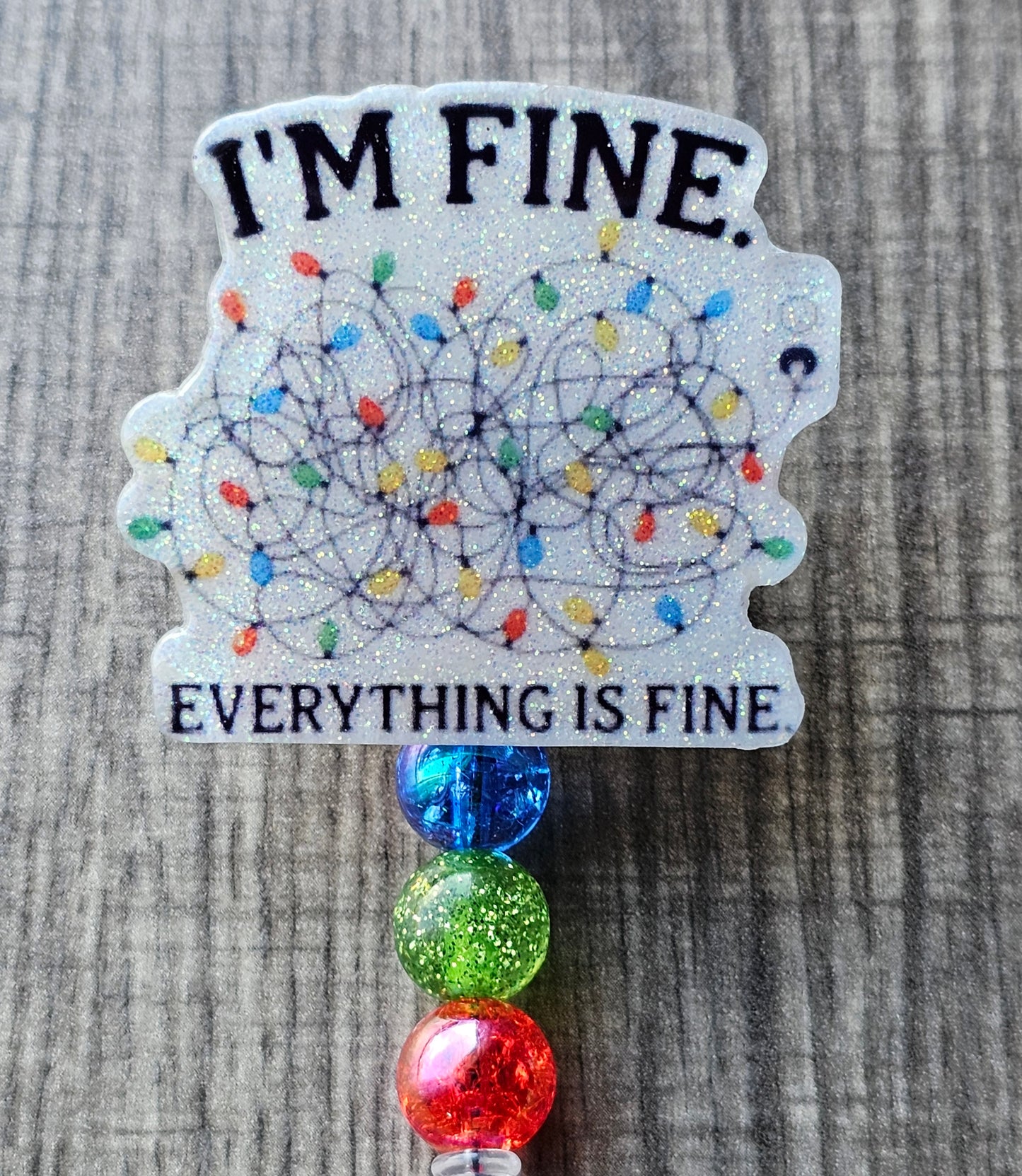 This badge reel features the phrase "I'm Fine, Everything is Fine" with tangled Christmas lights in the center.