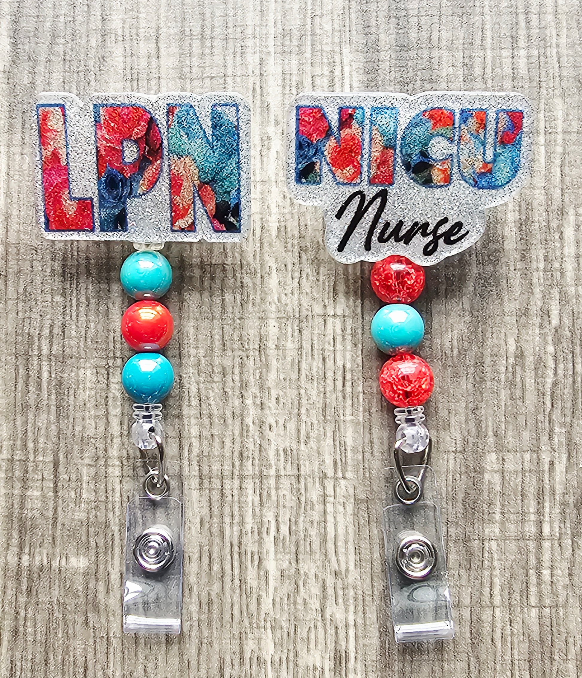 Pink and teal flower badge reel with OR Nurse title and color-coordinated clip.