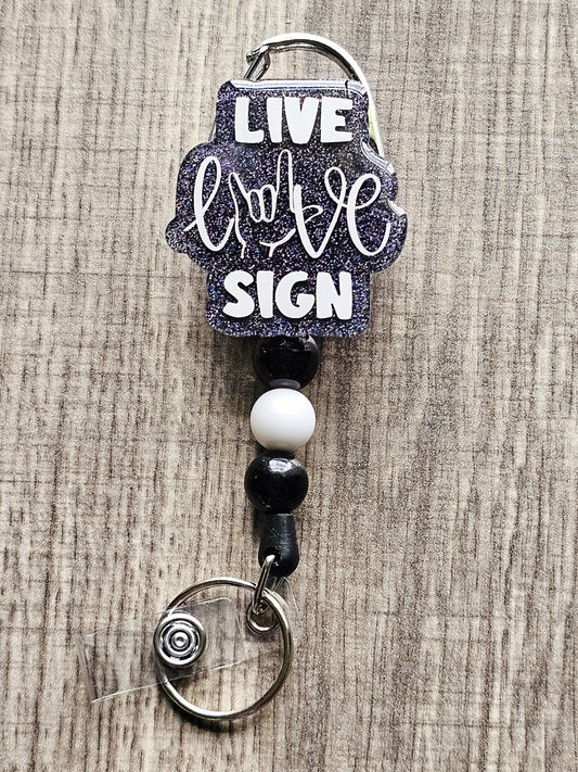 A badge reel with the statement live, love, sign, .