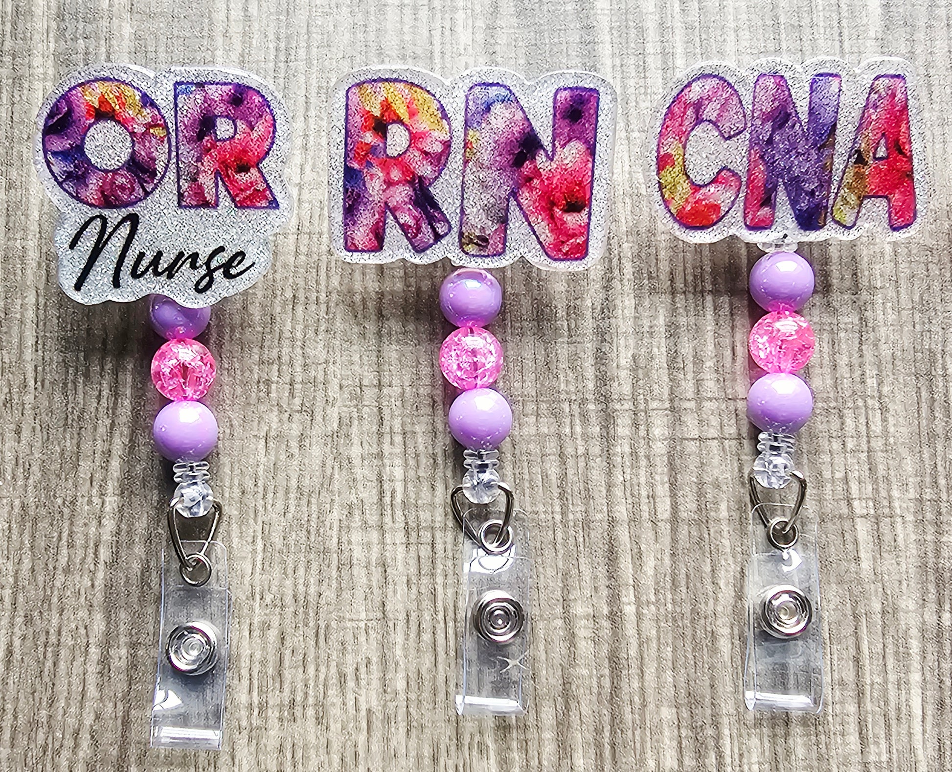 Floral badge reel in purple and pink with RN, OR and Nurse lettering and matching beads.