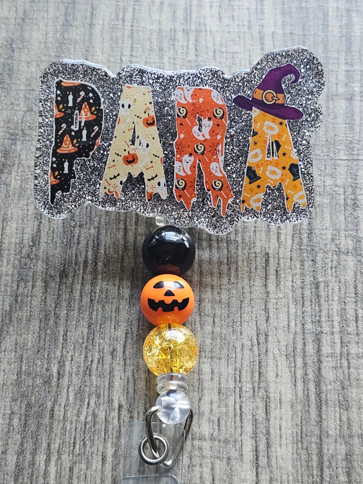 A badge reel with the word para to bring light to the work of paraprofessionals with a Halloween theme .