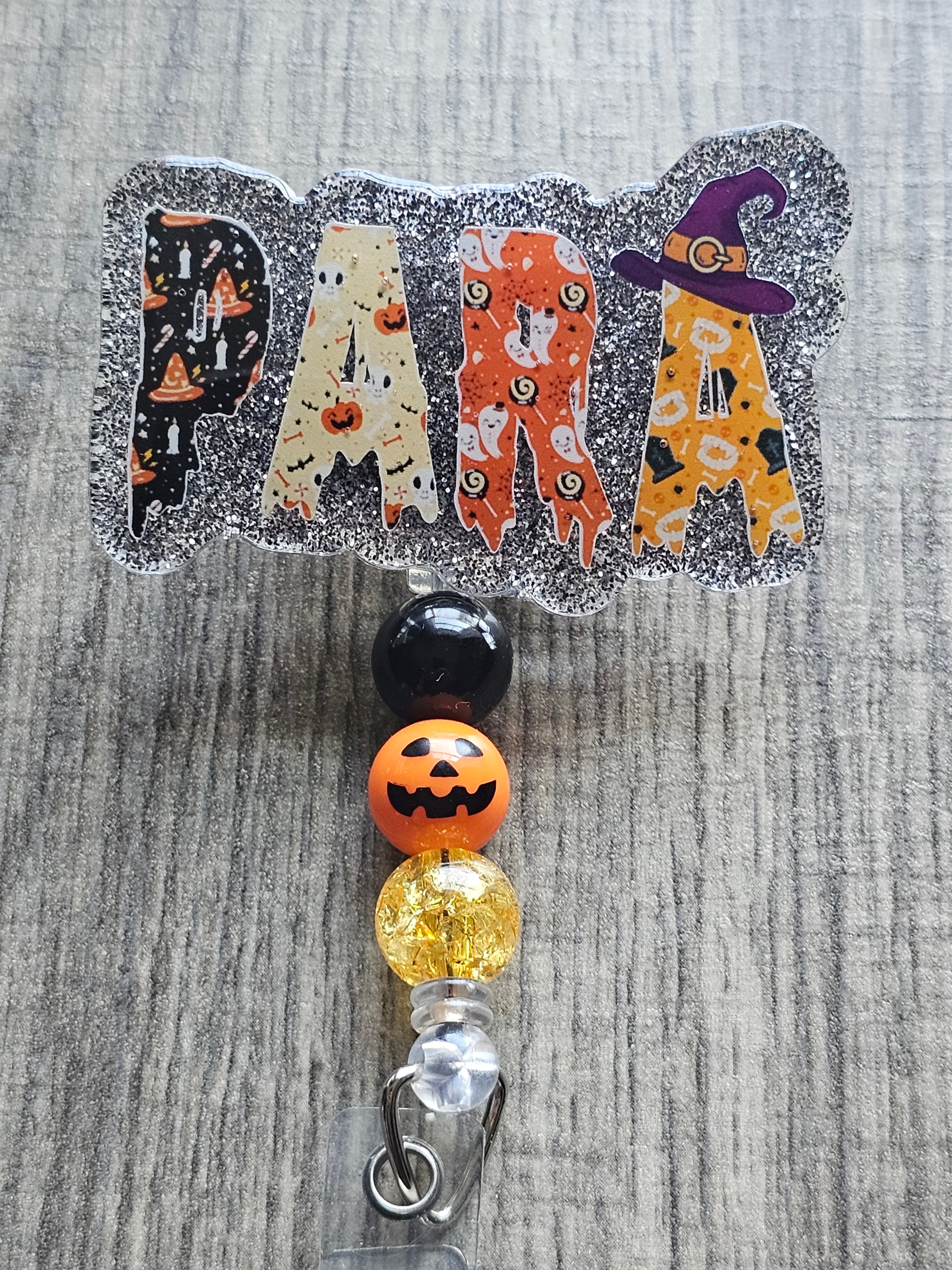 A badge reel with the word para to bring light to the work of paraprofessionals with a Halloween theme .
