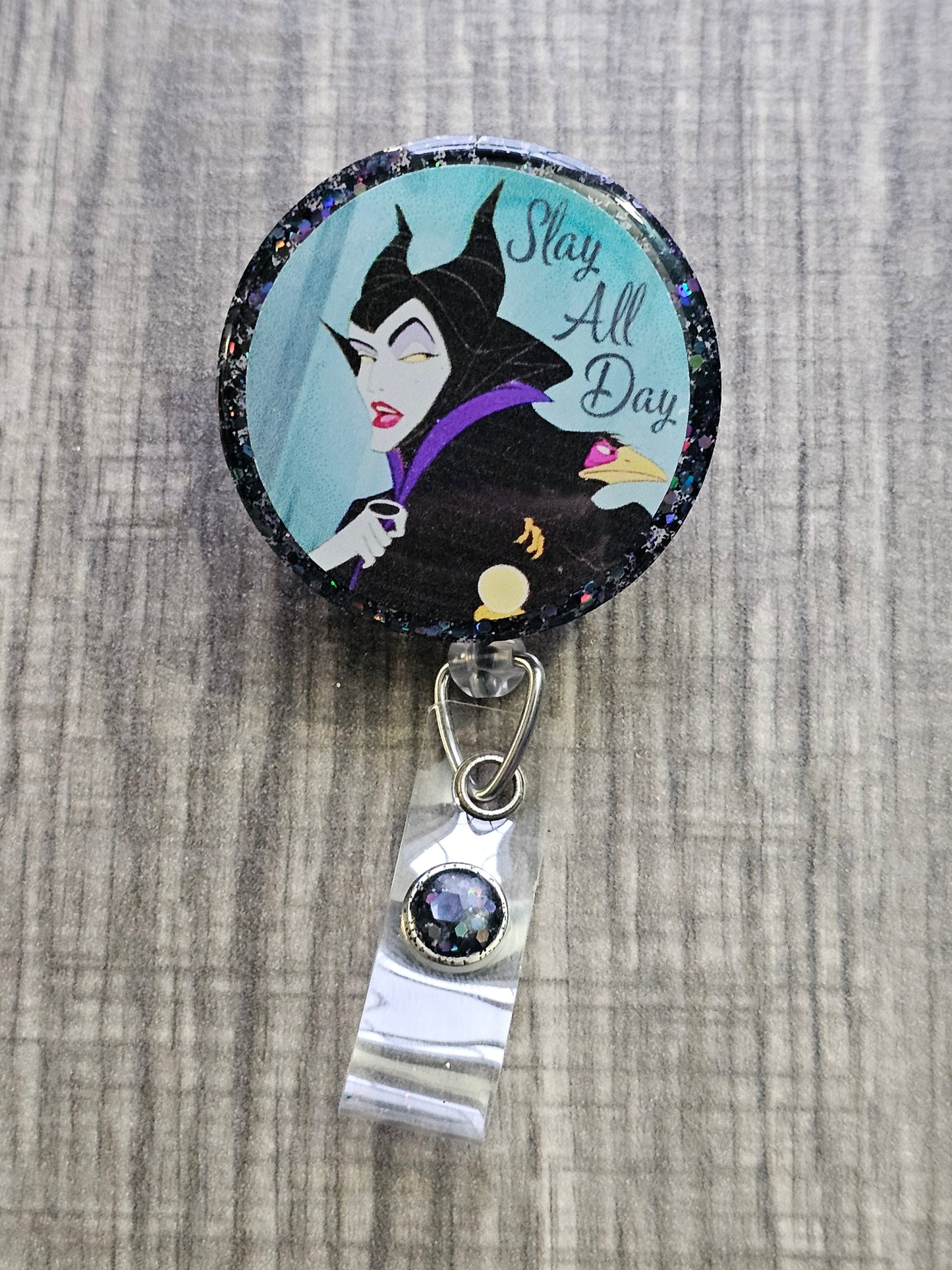 A Halloween themed Badge Reel with the statement Slay All Day Enchantress decorated in a Halloween theme; highlighting a powerful evil queen