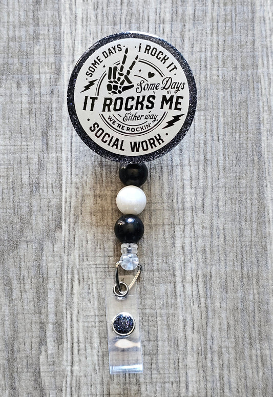Social work-themed badge reel with the phrase "Some Days I Rock It, Some Days It Rocks Me – Either Way, We’re Rockin’" on a glittery background.