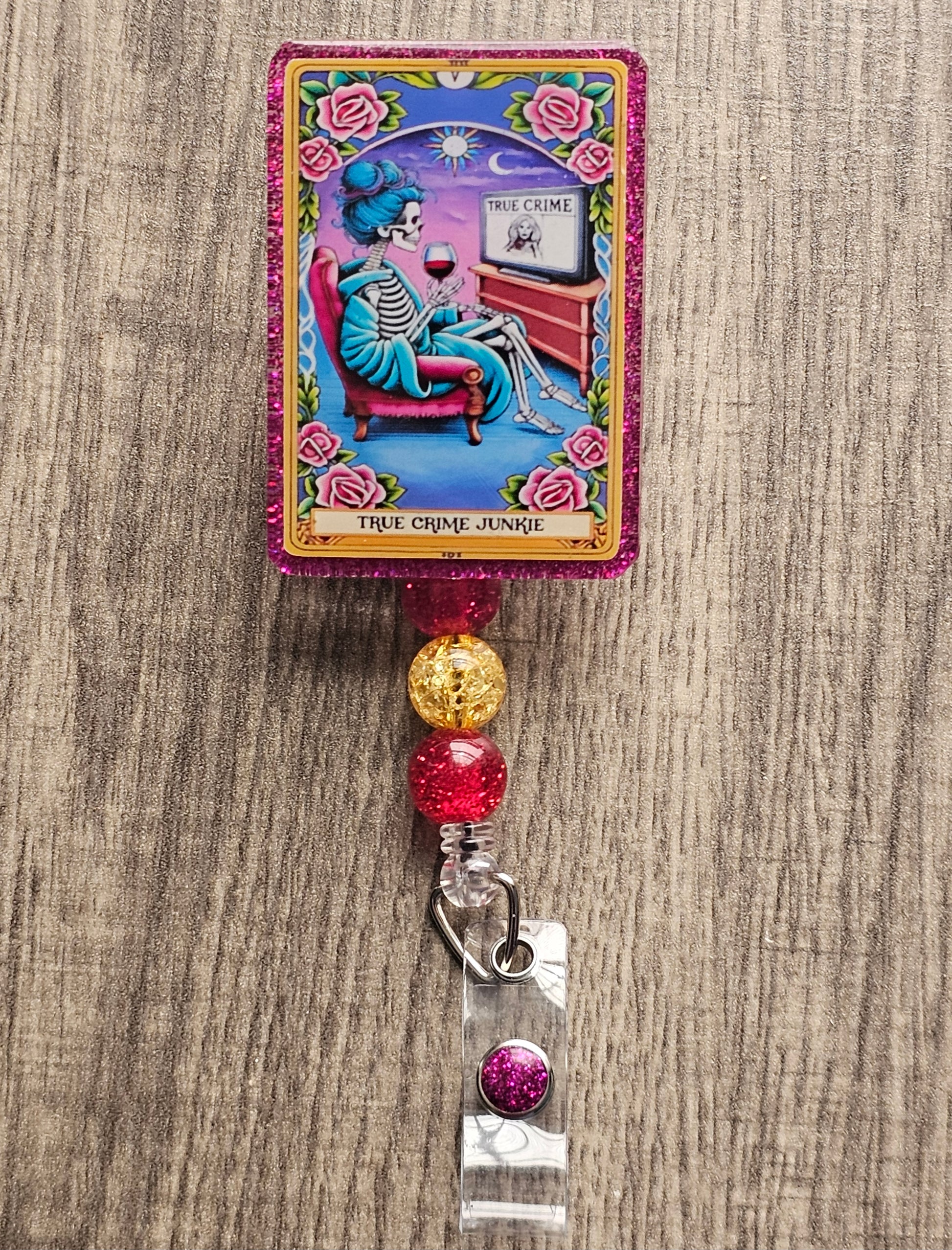 Badge Reel Shaped as a Tarot Card featuring a skeleton lady in a living room holding a glass of wine while watching a true crime documentary, titled True Crime Junkie
