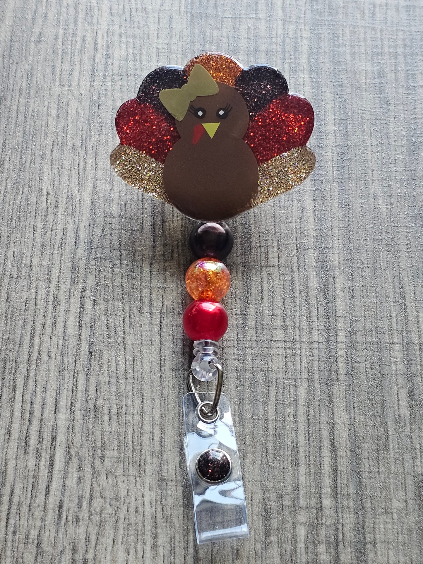 a badge reel featuring a turkey while also being shaped like a turkey