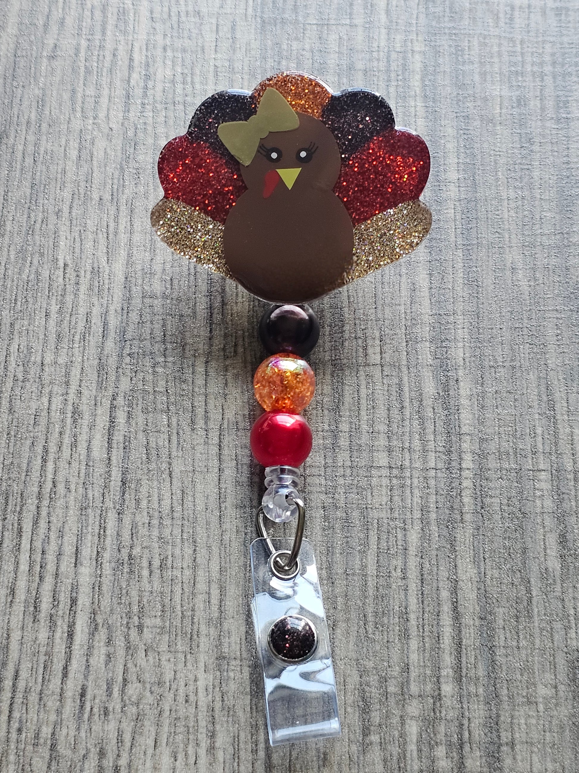 a badge reel featuring a turkey while also being shaped like a turkey