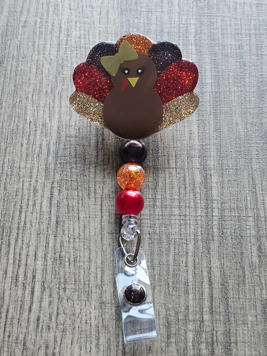 a badge reel featuring a turkey while also being shaped like a turkey