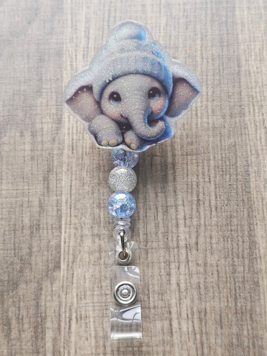 A badge reel featuring an irresistibly cute elephant bundled up in a festive winter hat.