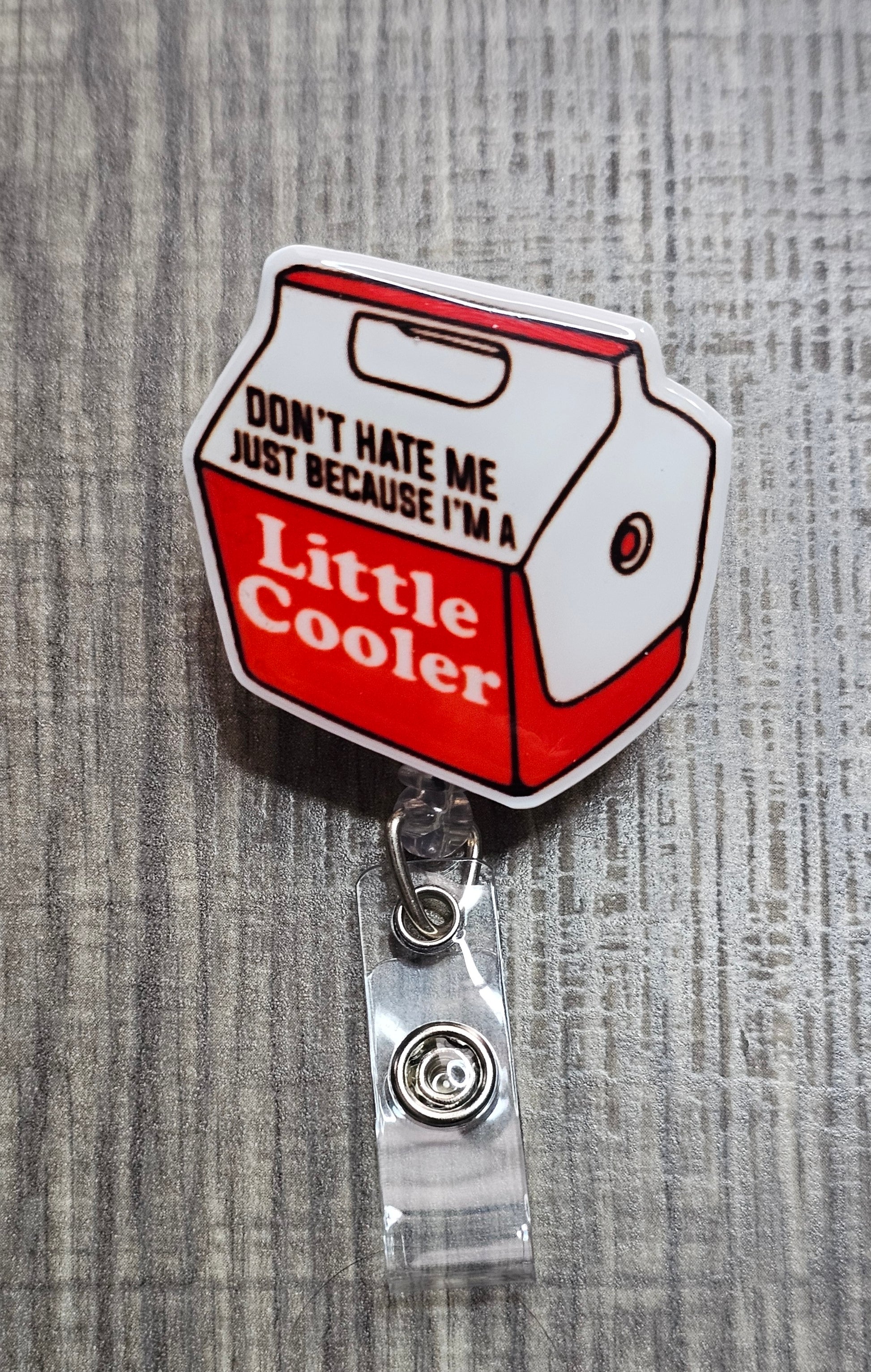 Retractable badge reel shaped like a blue cooler with the pun "Don't hate me because I'm a little Cooler.