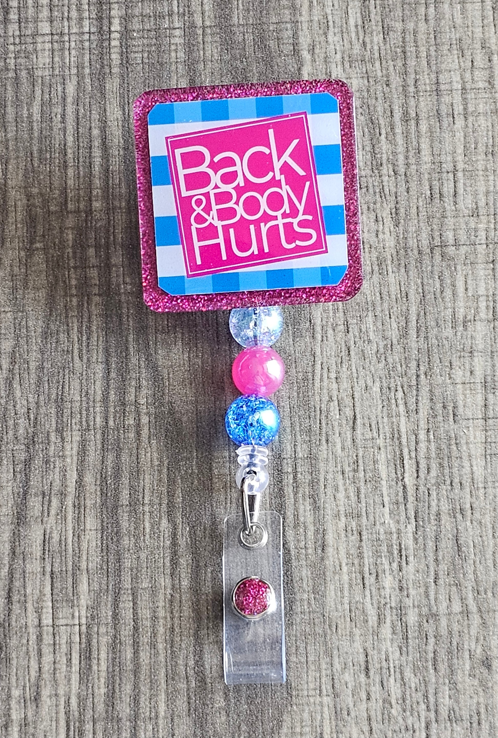 A badge reel that states back and body hurts 