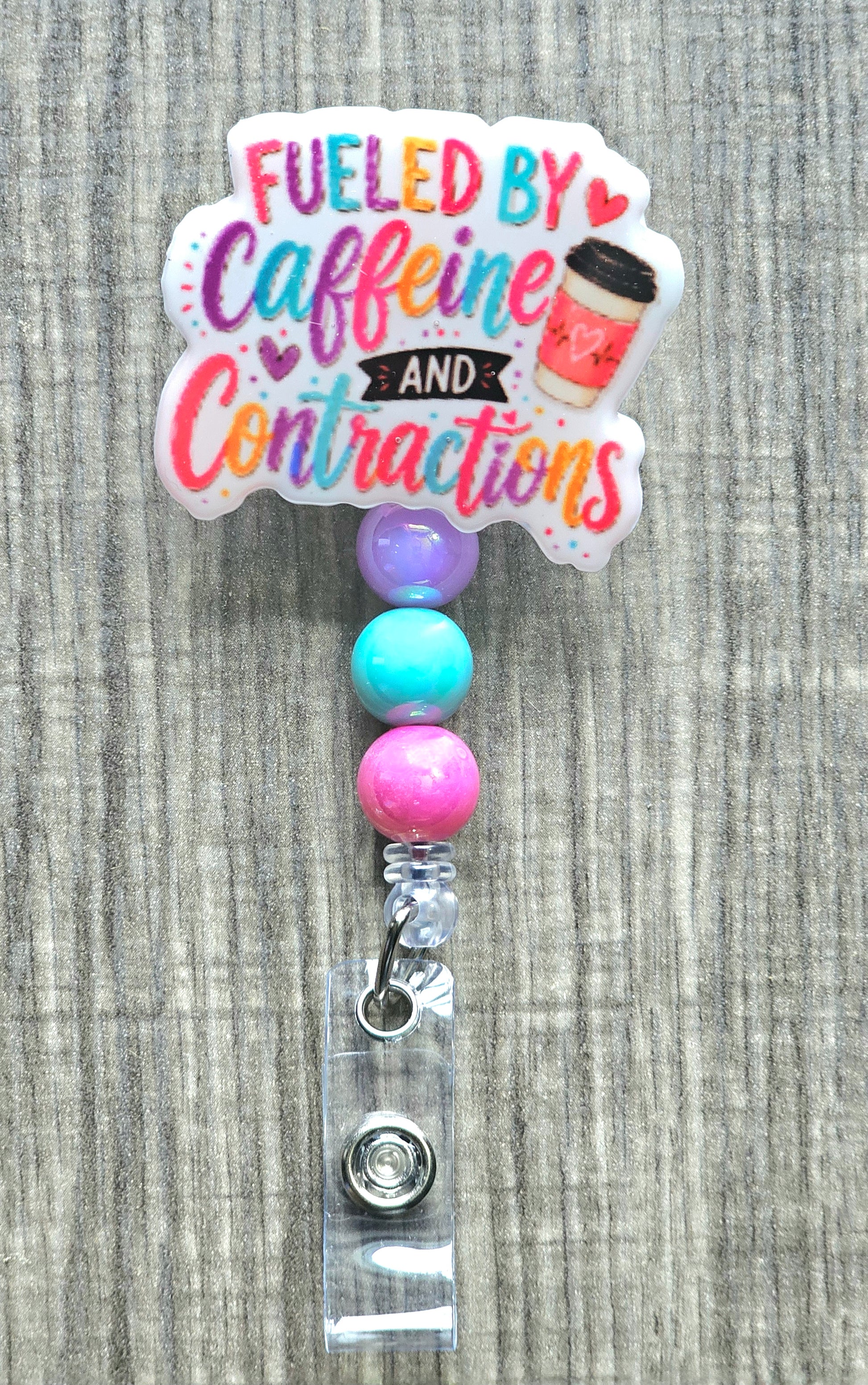 Colorful hand-lettered text reading "Fueled by Caffeine and Contractions" next to a pink coffee cup.