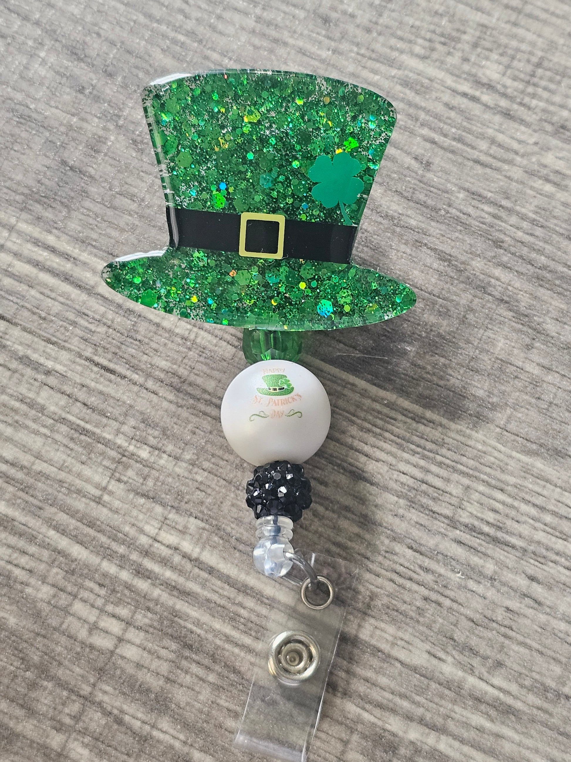 A festive badge reel featuring a classic St. Patrick’s Day hat! Adorned with a vibrant green clover and a golden buckle.