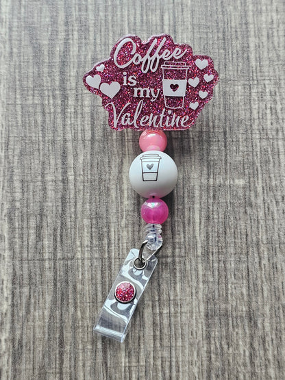 A badge Reel stating Coffee is my valentine featuring a coffee cup along with some hearts surround the badge reel 