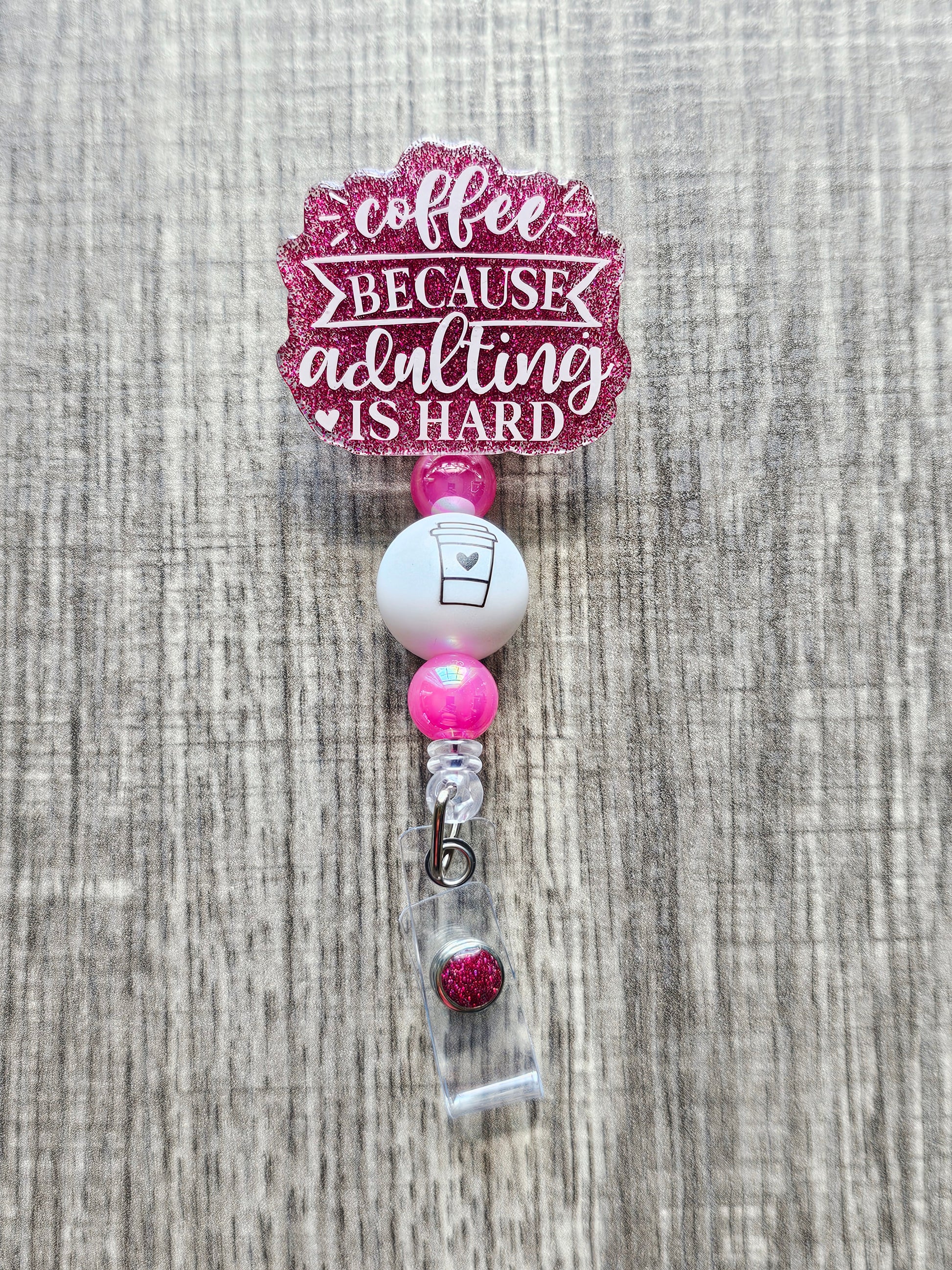 Humorous badge reel that says "Coffee Because Adulting is hard" with a coffee cup embedded on its bead.