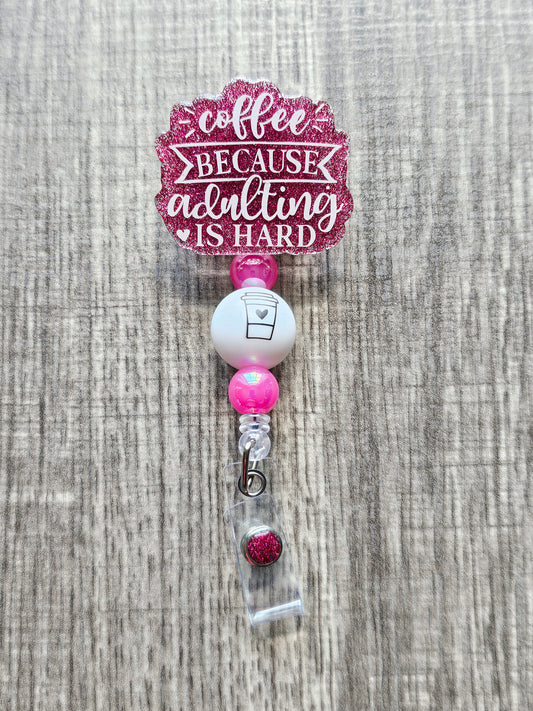 Humorous badge reel that says "Coffee Because Adulting is hard" with a coffee cup embedded on its bead.