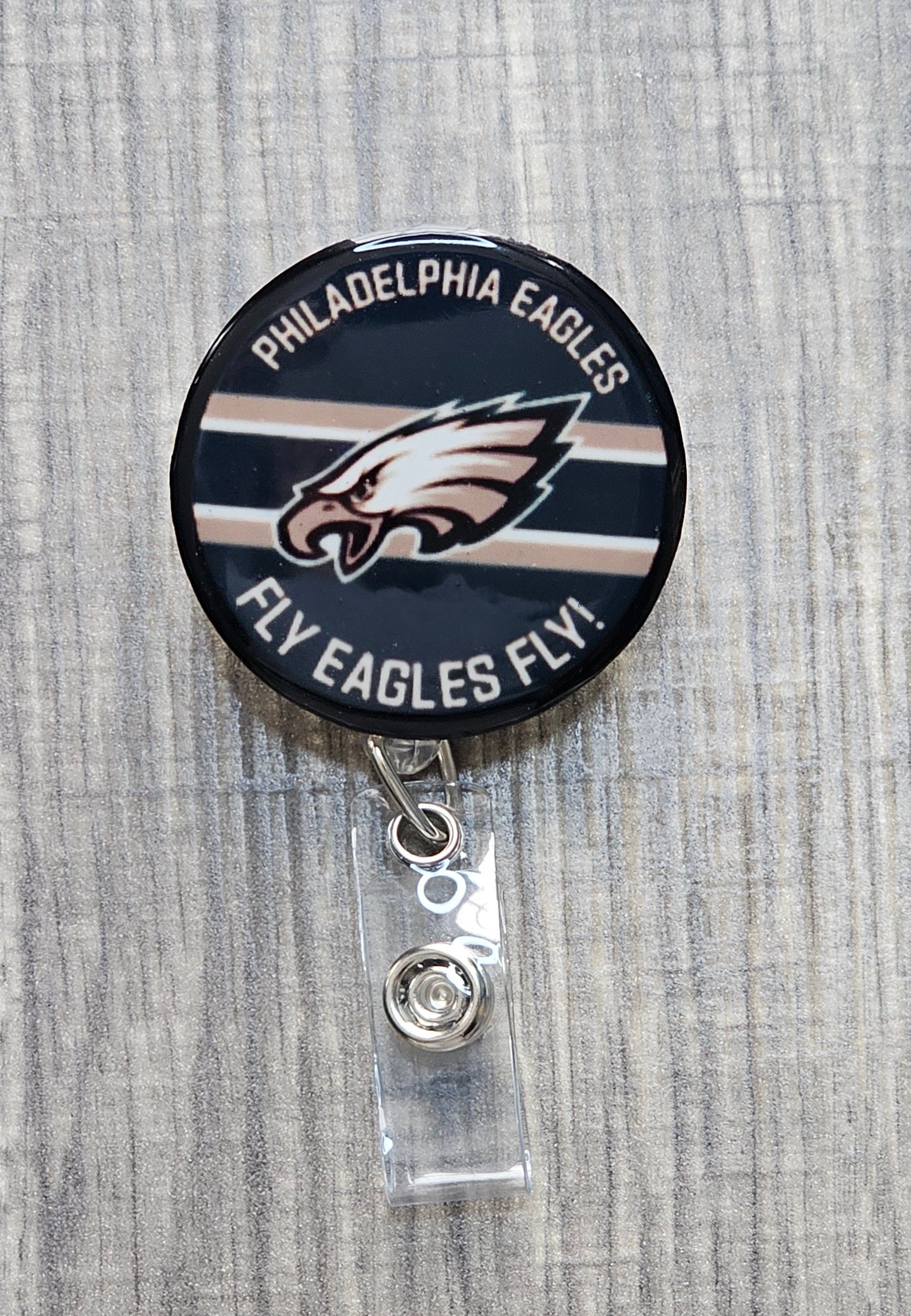 Philadelphia Eagles badge reel with fierce eagle logo and Fly Eagle Fly text in a circular pattern.