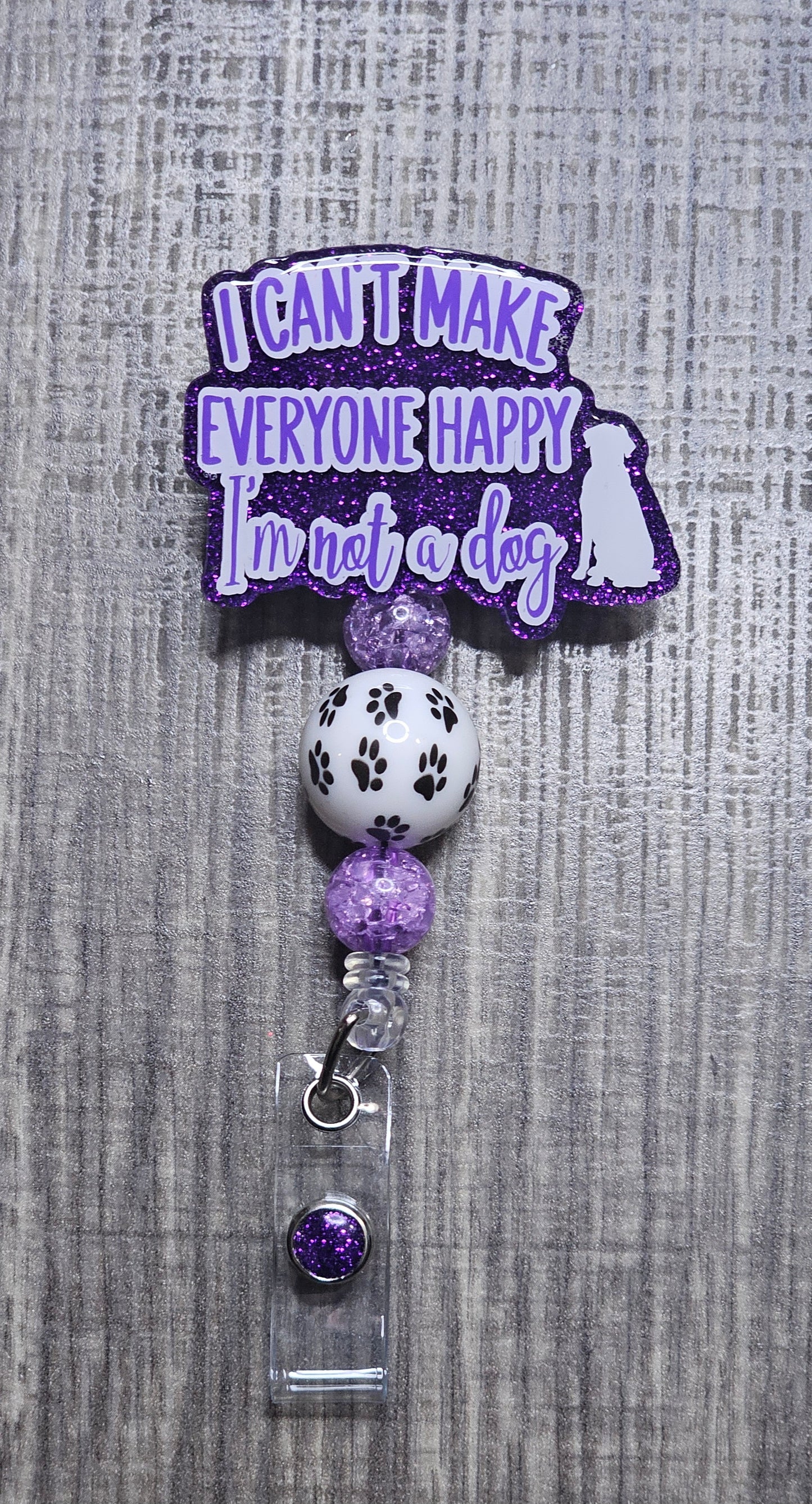 Badge holder with a humorous quote "I can't make everyone happy, I'm not a dog" on a gray textured background