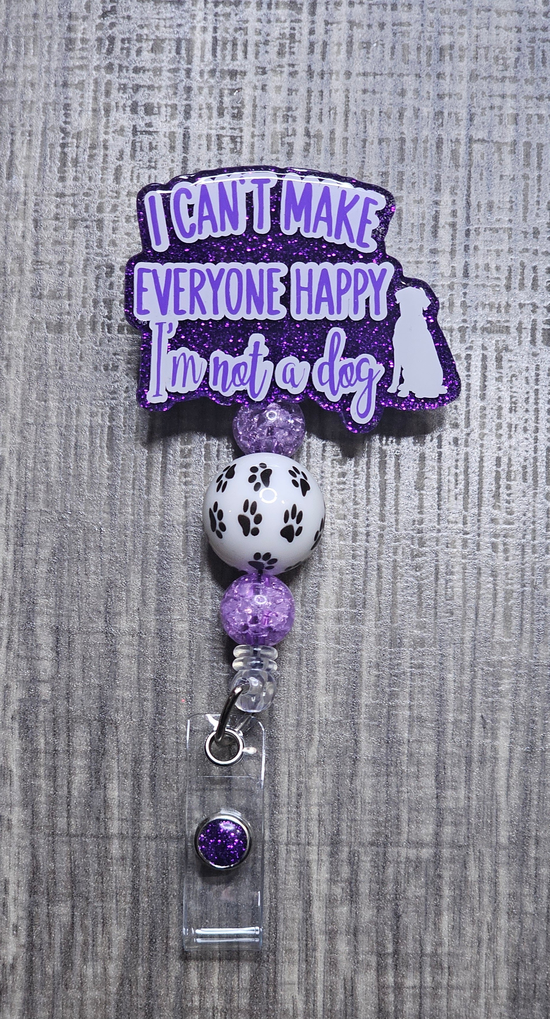 Badge holder with a humorous quote "I can't make everyone happy, I'm not a dog" on a gray textured background