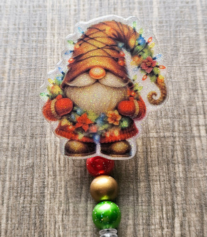 A badge reel that features a  cozy gnome dressed in a festive sweater adorned with colorful Christmas lights