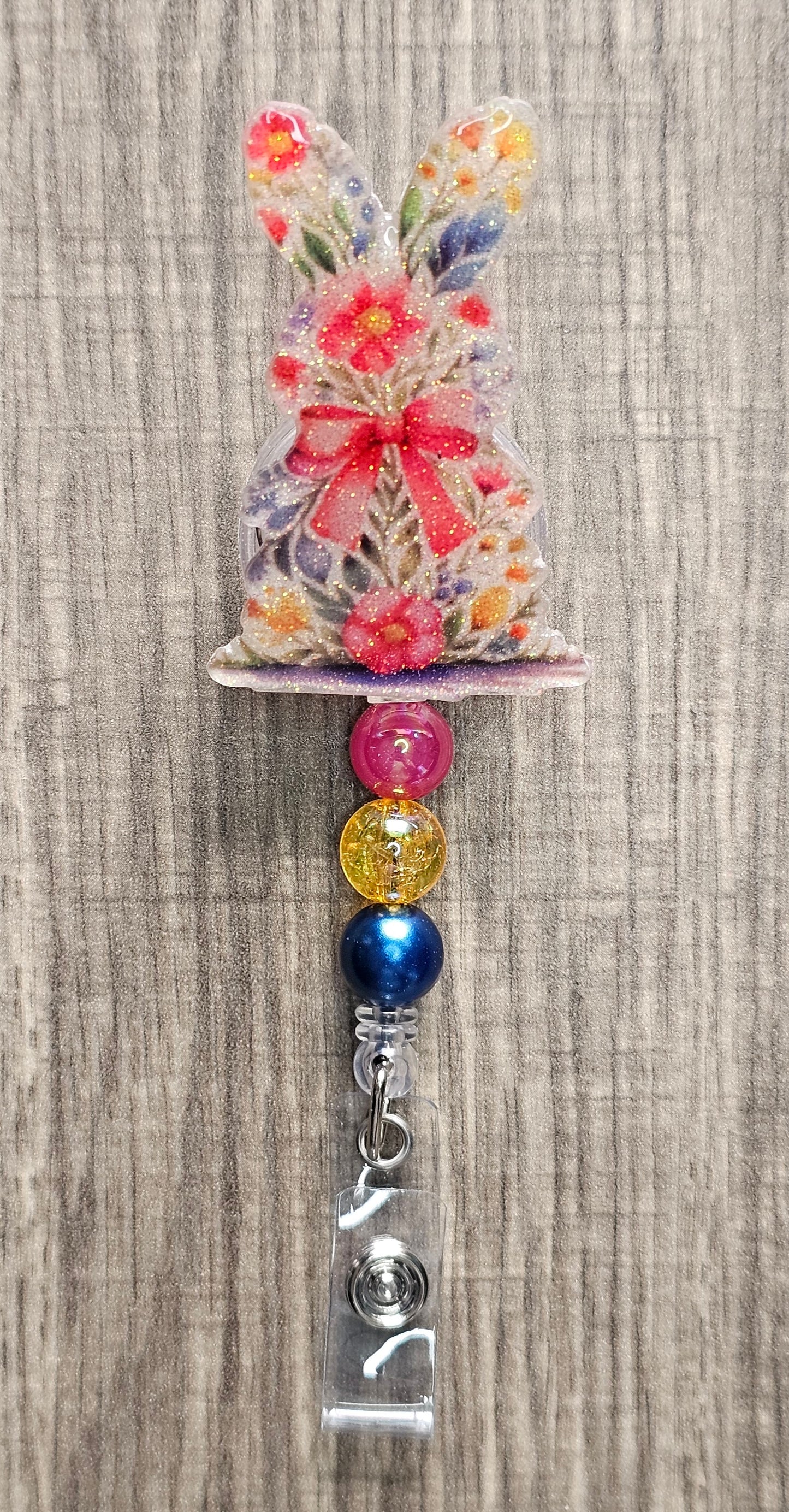 Retractable badge reel featuring a bunny with a floral pattern and three coordinating silicone beads.