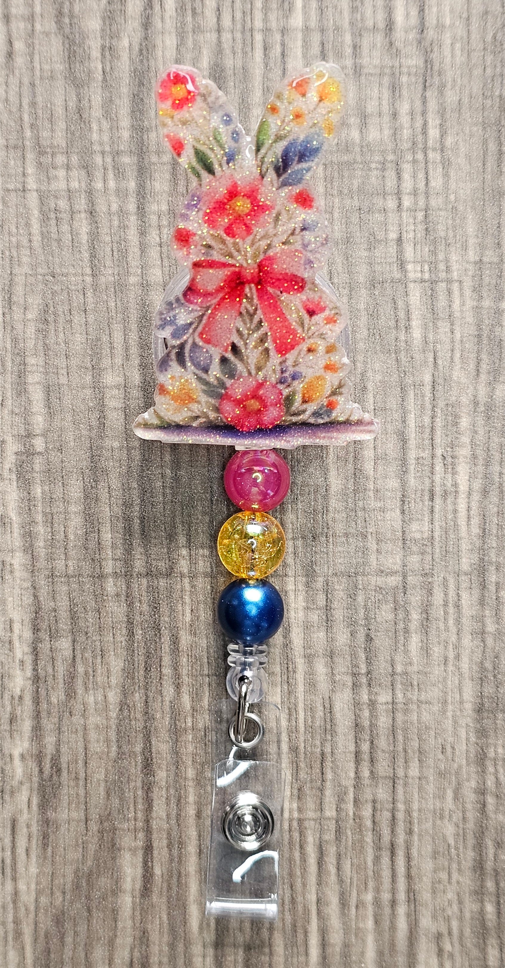 Retractable badge reel featuring a bunny with a floral pattern and three coordinating silicone beads.