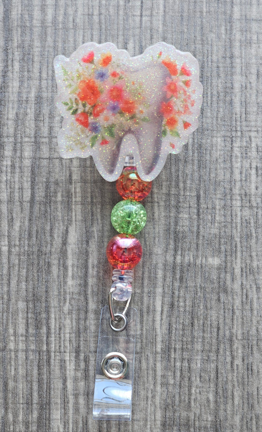 Adorable tooth badge reel surrounded by flowers with matching colorful beads.