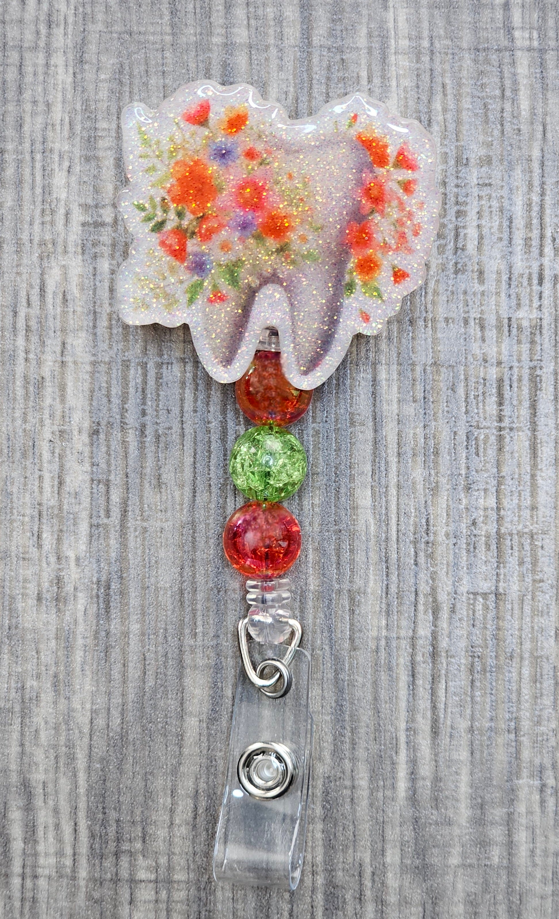Adorable tooth badge reel surrounded by flowers with matching colorful beads.