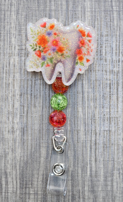 Adorable tooth badge reel surrounded by flowers with matching colorful beads.