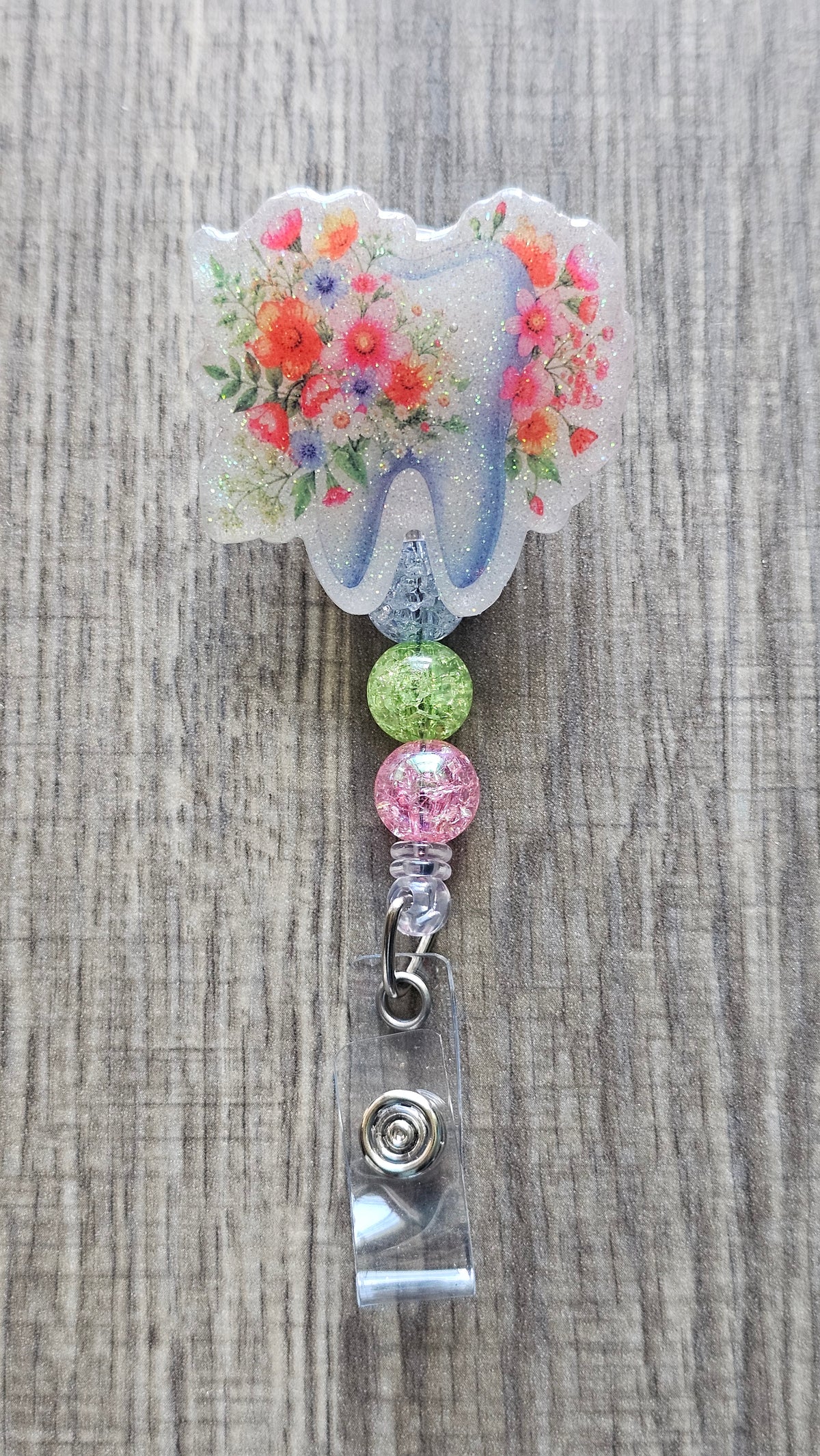 Adorable tooth badge reel surrounded by flowers with matching colorful beads.