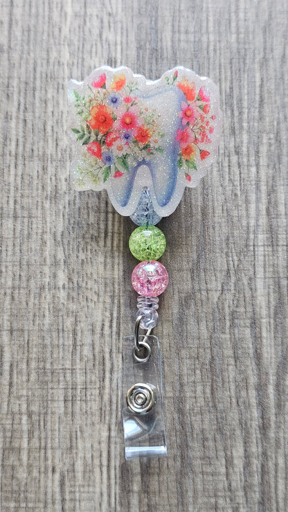 Adorable tooth badge reel surrounded by flowers with matching colorful beads.