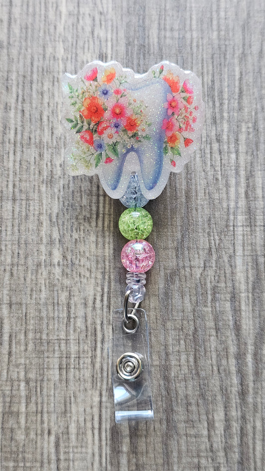 Adorable tooth badge reel surrounded by flowers with matching colorful beads.