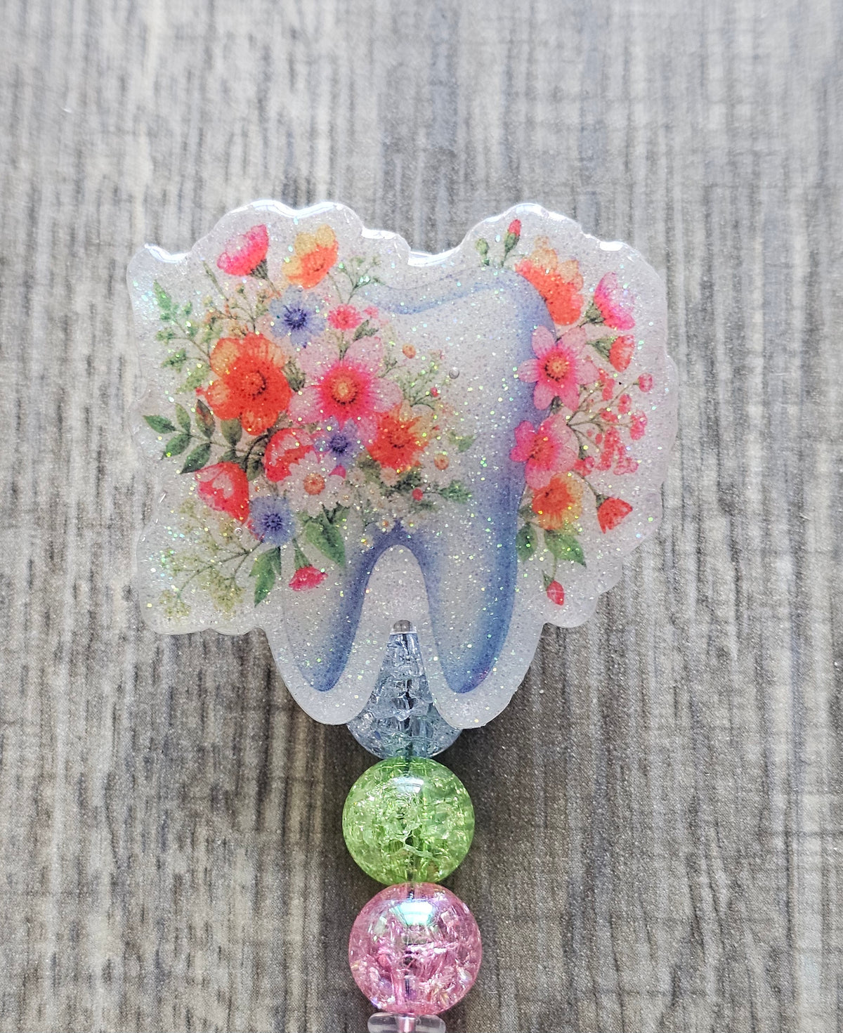 Adorable tooth badge reel surrounded by flowers with matching colorful beads.