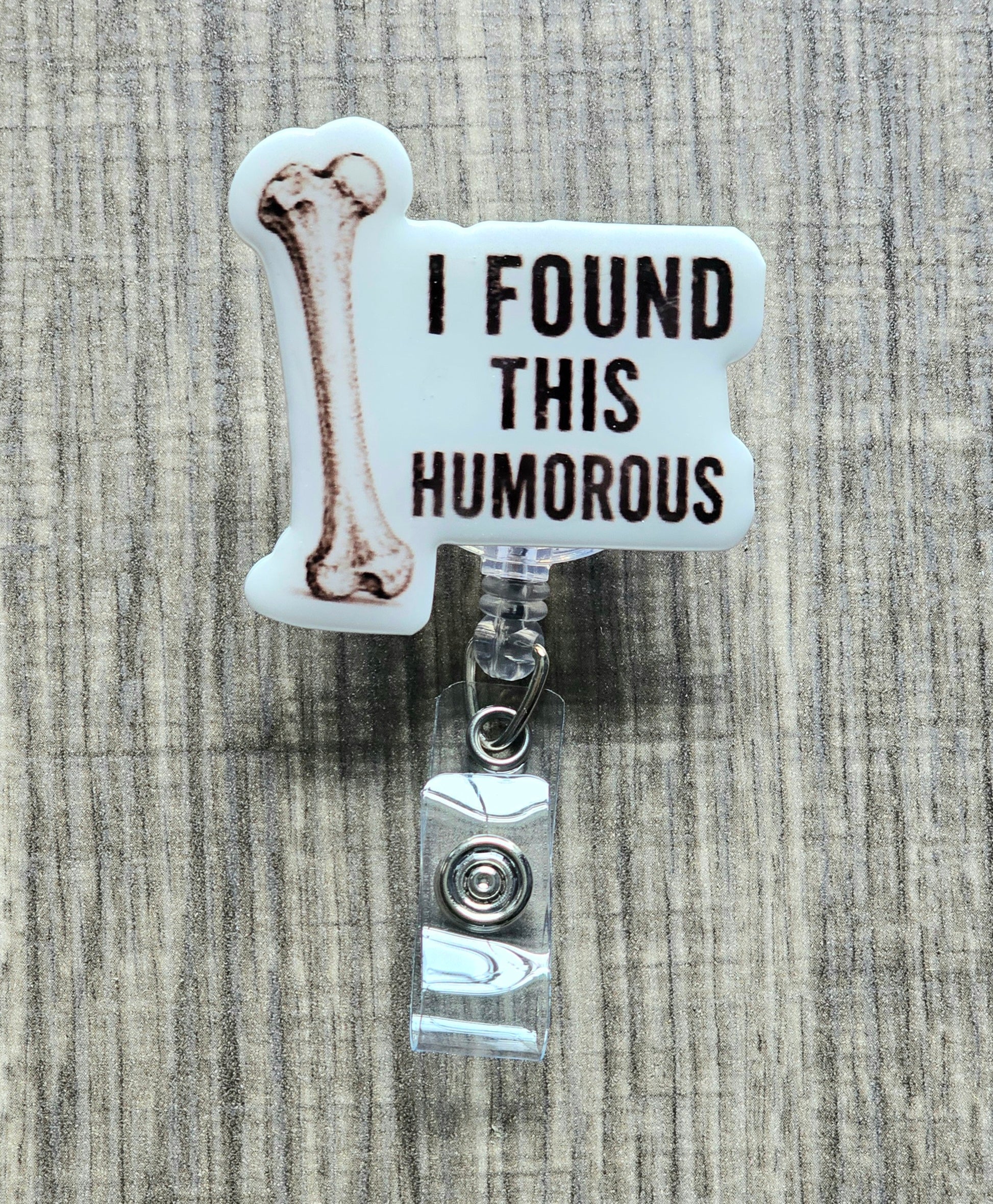 Retractable badge reel featuring an acrylic topper with a medical illustration of a humerus bone and the text "I Found This Humorous."