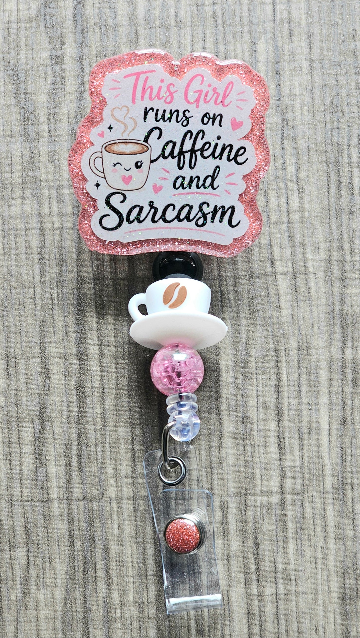 A cute smiling coffee cup surrounded by pink hearts and the text "This Girl runs on Caffeine and Sarcasm".