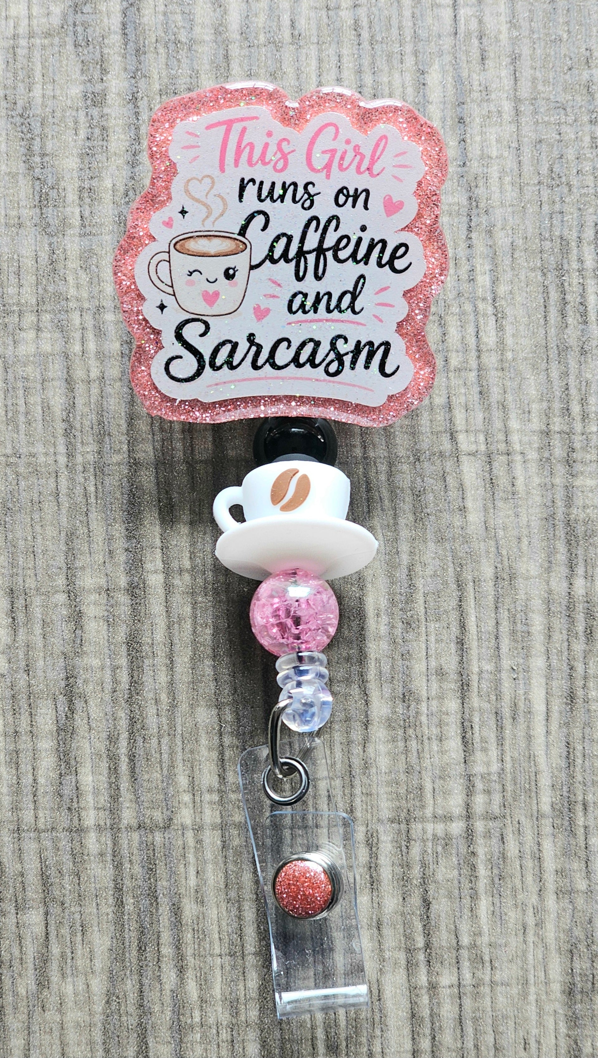 A cute smiling coffee cup surrounded by pink hearts and the text "This Girl runs on Caffeine and Sarcasm".