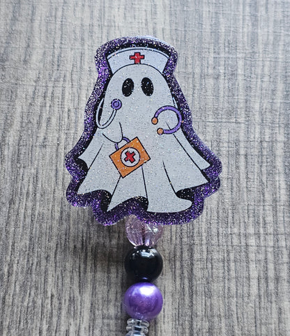  a badge reel shaped as a ghost with the design of a ghost nurse with a nursing hat, stethoscope along with a first aid kit 