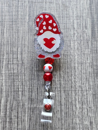 A gnome in a valentine's day hat holding a heart badge reel