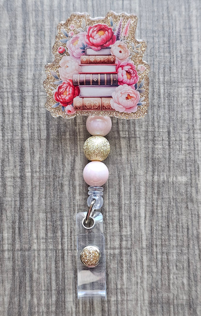  Book stack badge reel with flowers on gold acrylic with coordinating beads.
