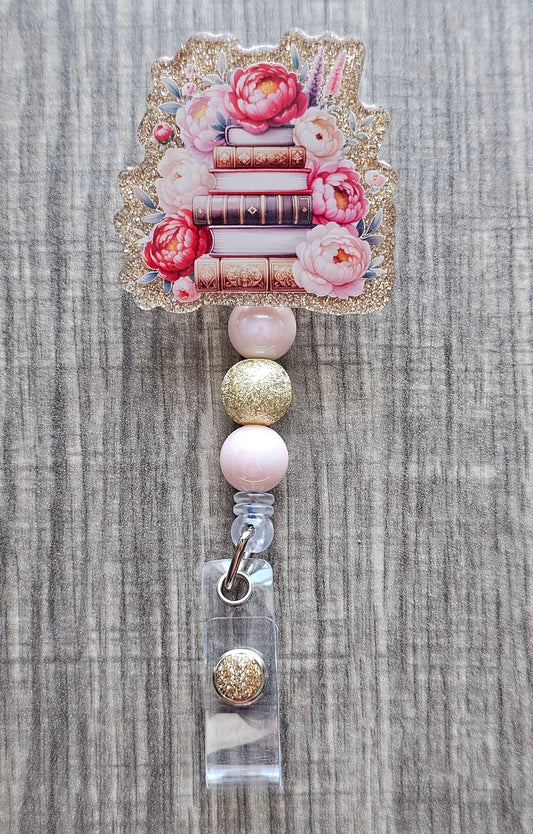  Book stack badge reel with flowers on gold acrylic with coordinating beads.