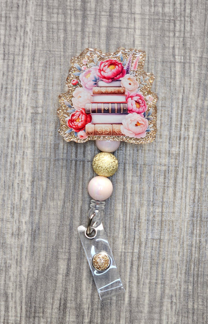 Book stack badge reel with flowers on gold acrylic with coordinating beads.