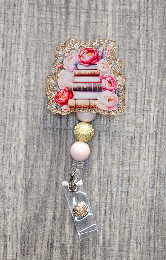 Book stack badge reel with flowers on gold acrylic with coordinating beads.