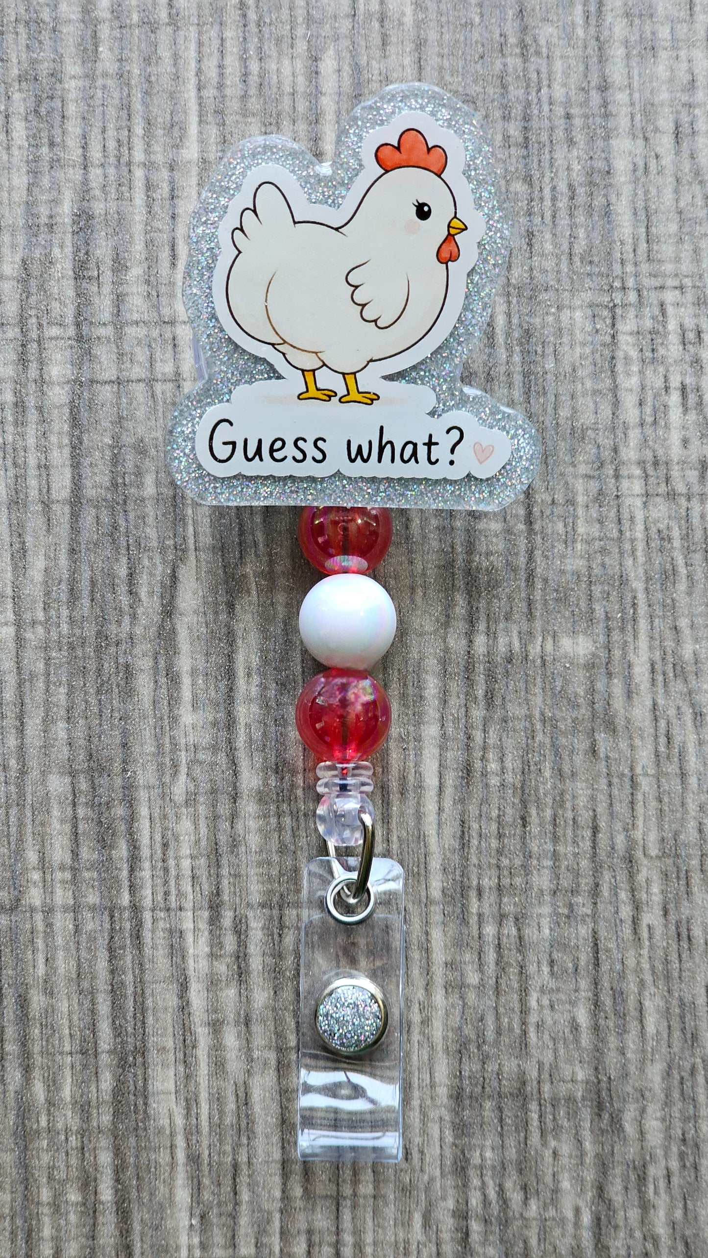 Cute white cartoon chicken looking over its shoulder with the text "Guess what?" written below, perfect for a funny badge reel.