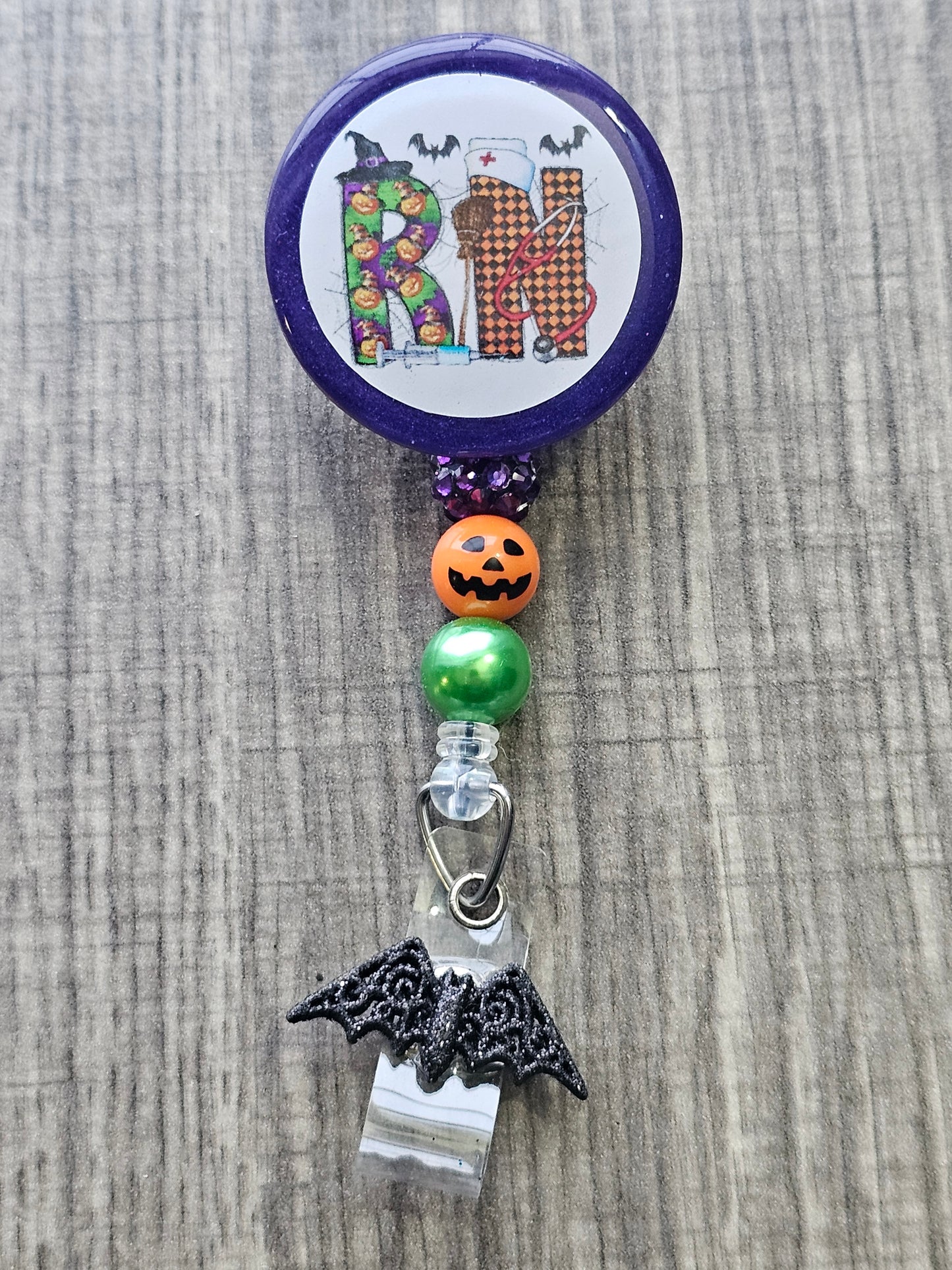 A Halloween themed badge with the letters RN in support of registered Nurses.