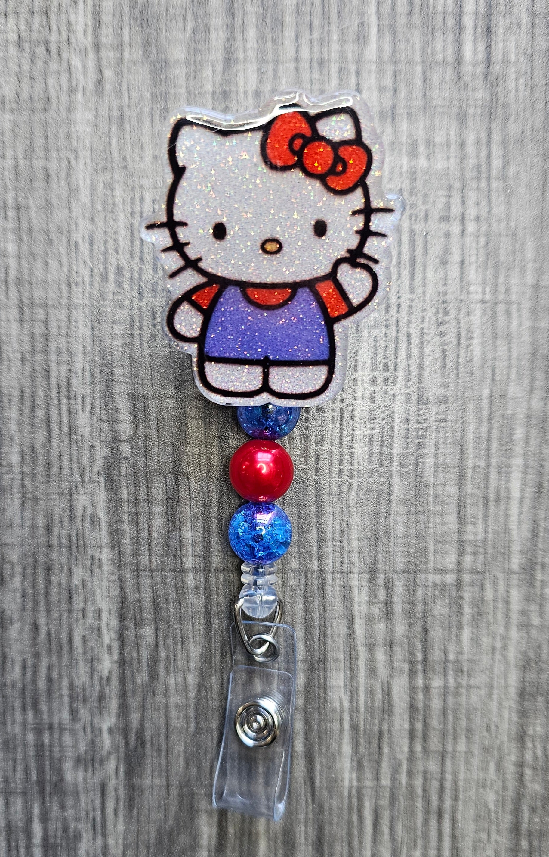 Hello Kitty badge holder with colorful beads on a gray background