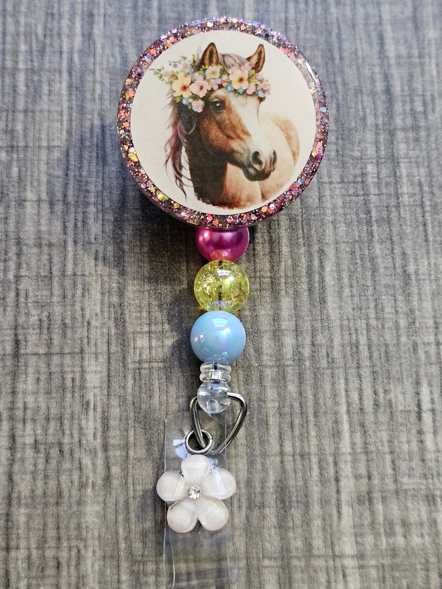  A Badge Reel featuring an adorable horse in a floral crown